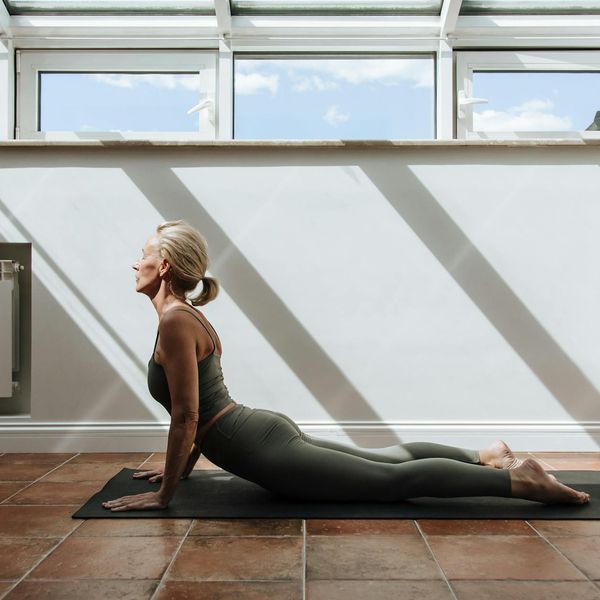 Woman stretching gracefully, bathed in warm light symbolizing energy.
